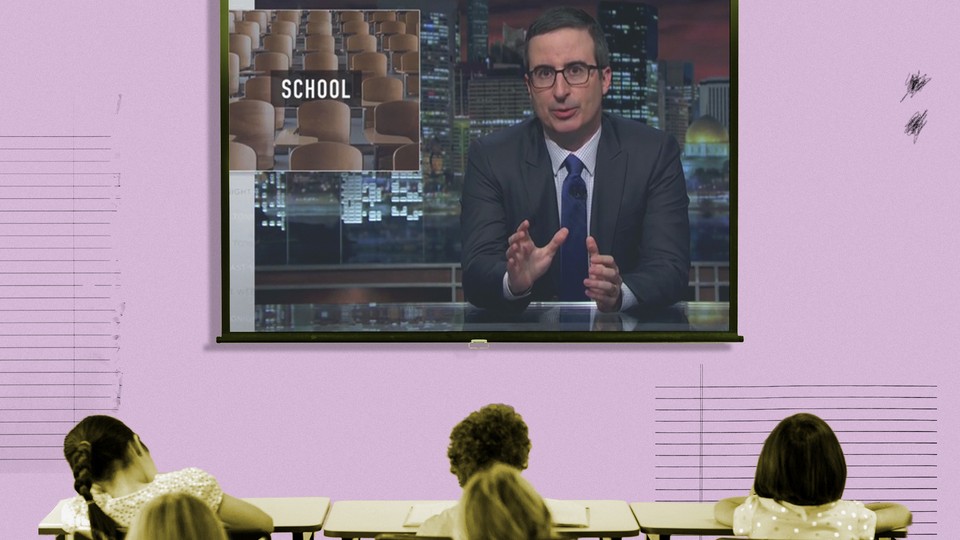 A projector screen is filled with a screengrab from John Oliver's show. The word "school" appears behind Oliver.