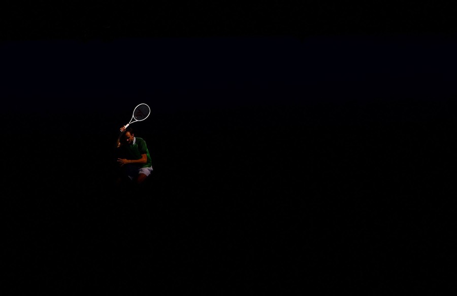 A tennis player against a very dark backdrop
