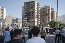 People gather at the scene of a residential complex struck by Israel in Tehran.