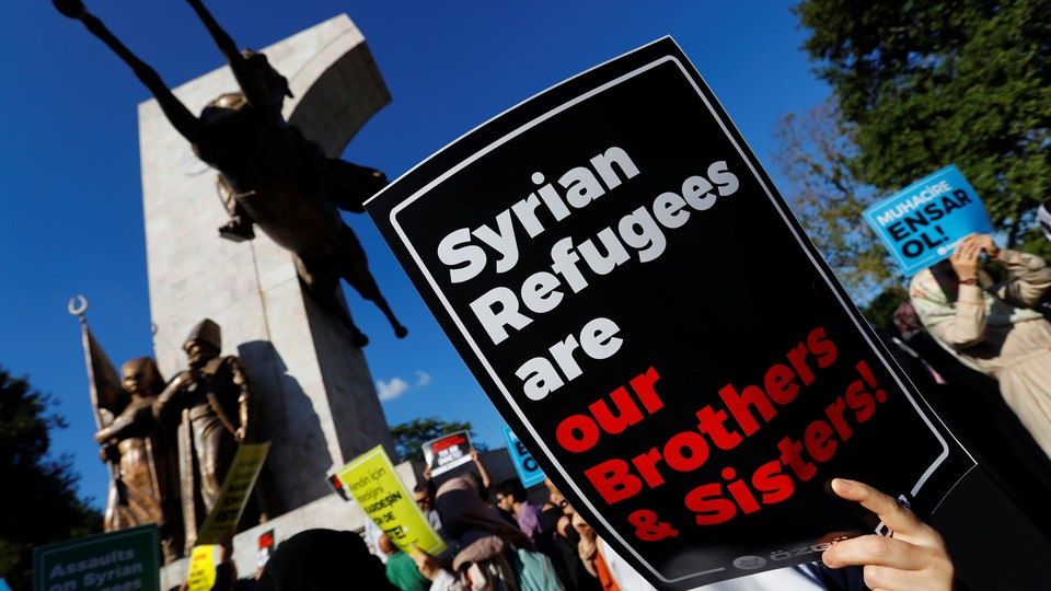 Demonstrators hold placards in support of Syrian refugees during a protest in Istanbul.