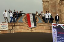 Mosul University students and activists place a national flag at the entrance of their university as they celebrate its liberation from ISIS.