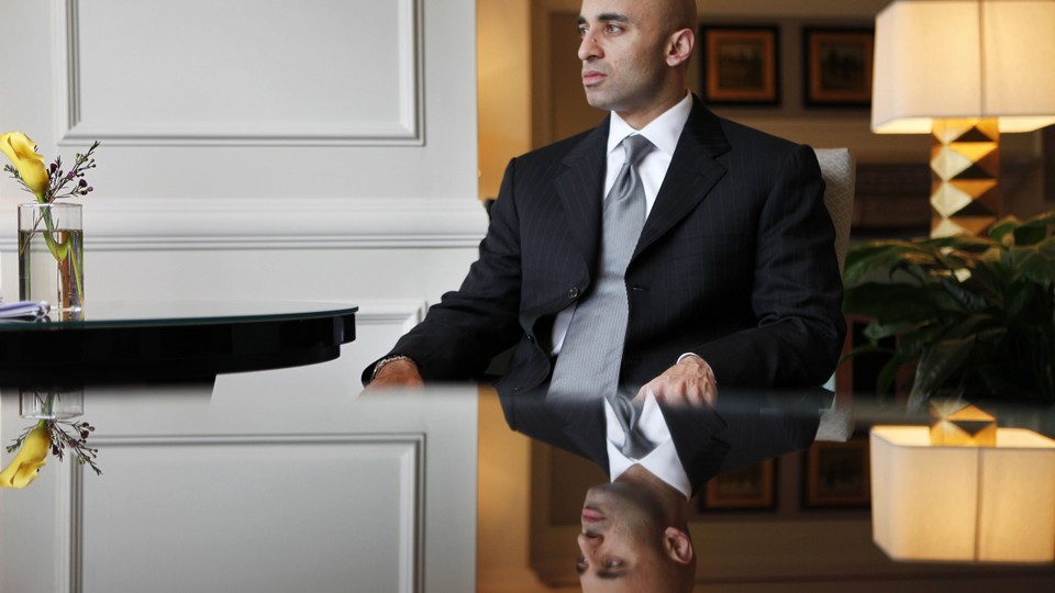 United Arab Emirates Ambassador to the U.S. Yousef al Otaiba, sits on a table and stares out the window. 
