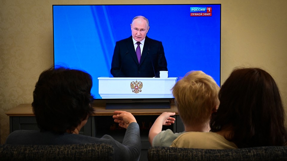 Photo of a family watching Vladimir Putin on television
