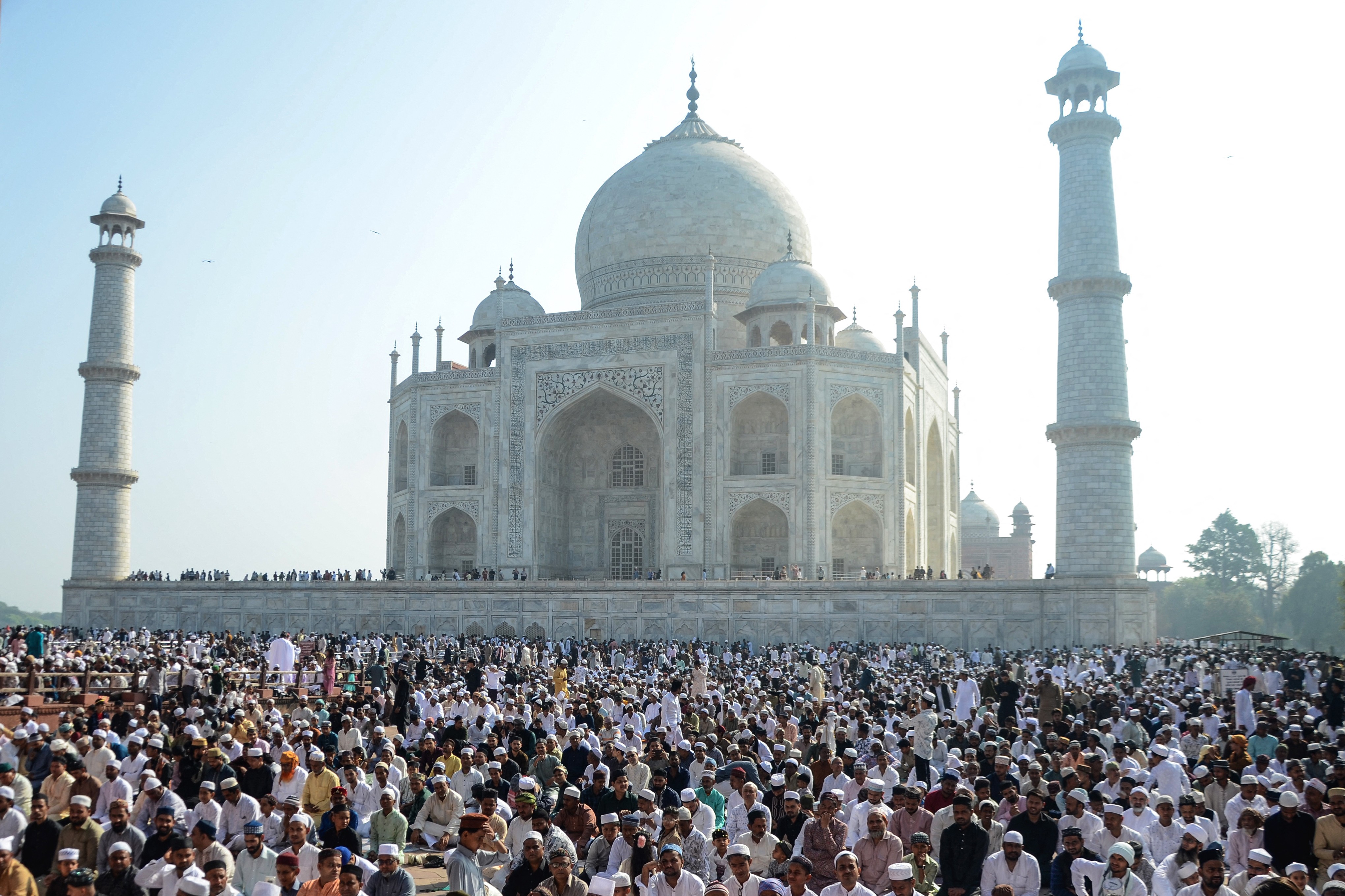 A large group of Muslims offer prayers outside the Taj Mahal.