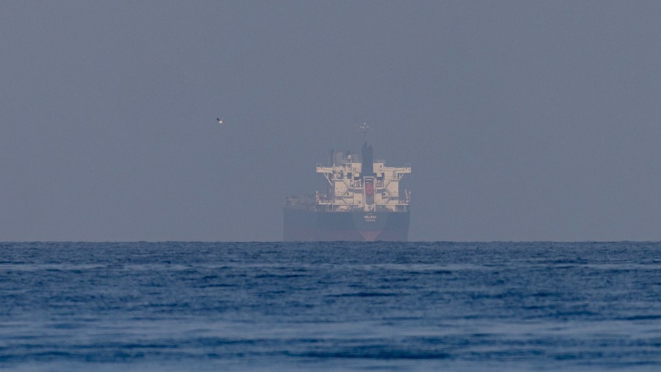A big ship appears to materialize through a fog in the Strait of Hormuz