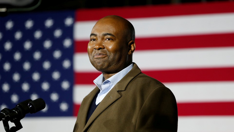 Jaime Harrison in front of an American flag