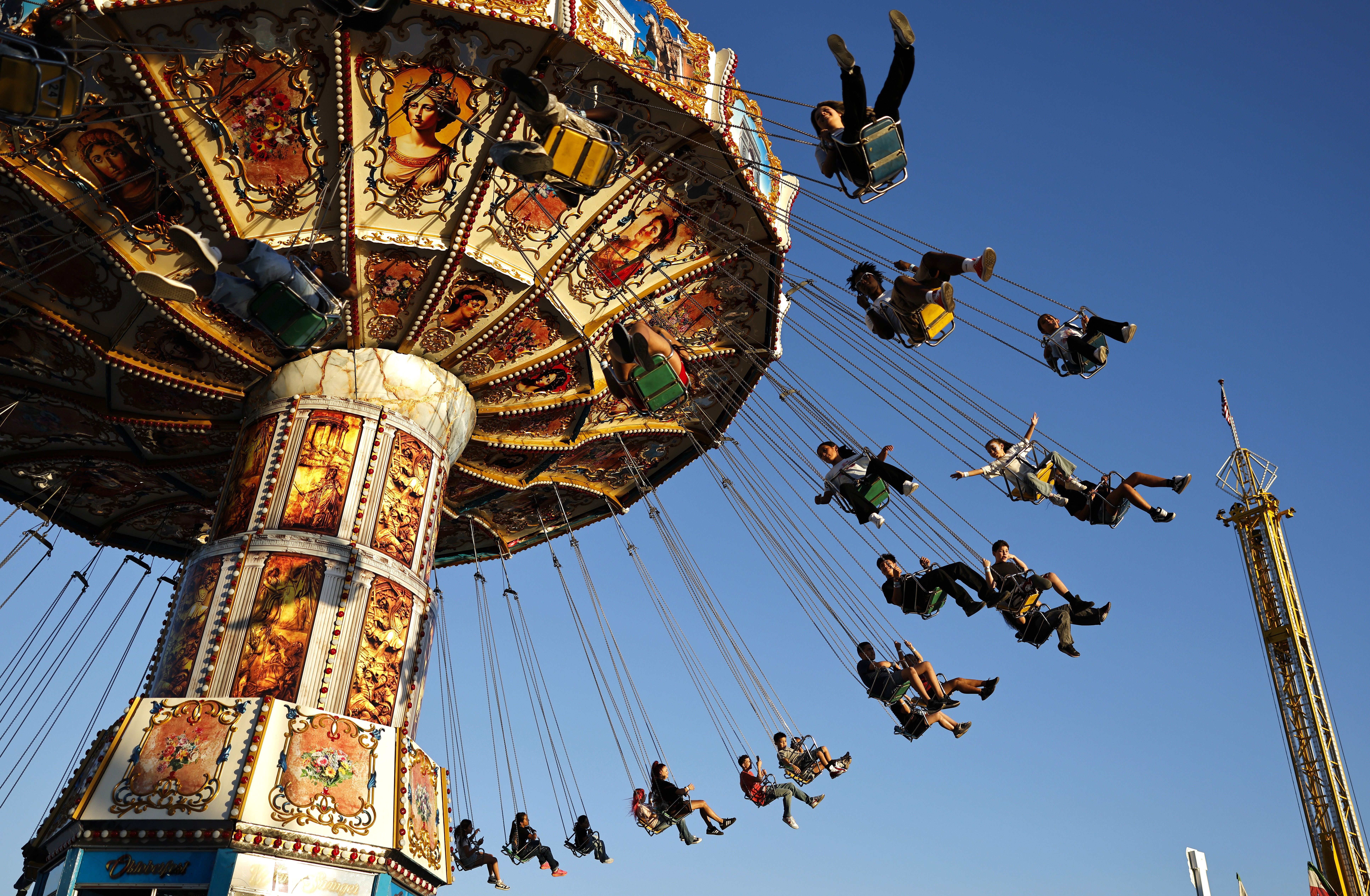 Fairgoers ride a spinning swing ride.