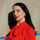 A photo of a woman with dark hair, bright-red lipstick, and a red blouse