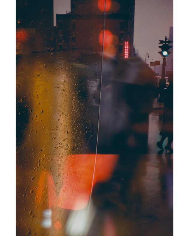 A blurry shot of New York in the rain and a black umbrella, through a rainy fog