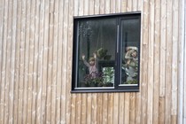 Three children stare out a window.