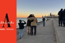 People look at the Chicago skyline at dusk.