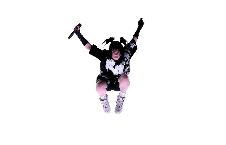 Performer Billie Eilish mid-jump during a concert