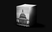 An illustration of a stack of papers. On the front side of the stack is an image of the U.S. Capitol
