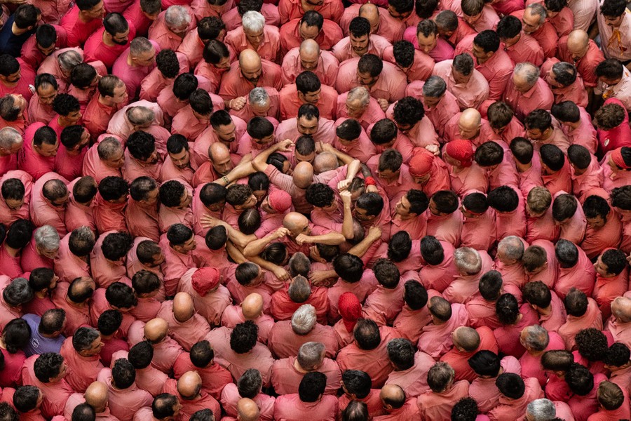 An overhead view of many people wearing red shirts smashed together, all facing a group of organizers in the center.