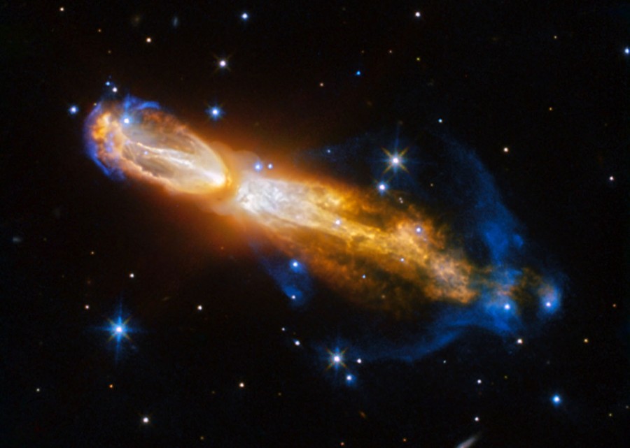 Glowing clouds of gas and dust blast out from a star in two opposite directions.