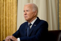 Joe Biden sits at a desk in the Oval Office