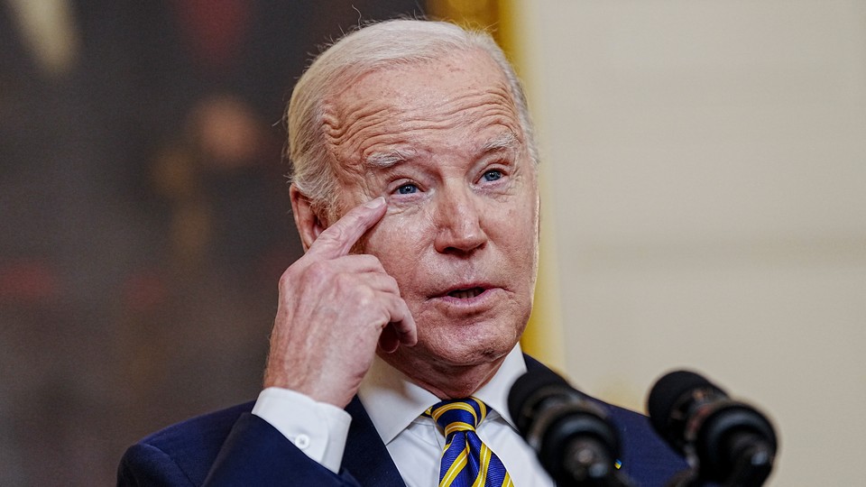 President Joe Biden speaks in front of microphones.