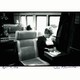 black-and-white photo of woman sitting in window seat on train, head bowed and writing on a briefcase on her lap, signed at bottom by photographer and hand-dated April 14, 1978