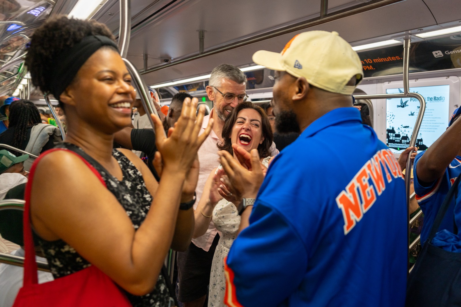 New Yorkers celebrate on a subway train.