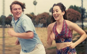 Cooper Hoffman and Alana Haim running outside in "Licorice Pizza"