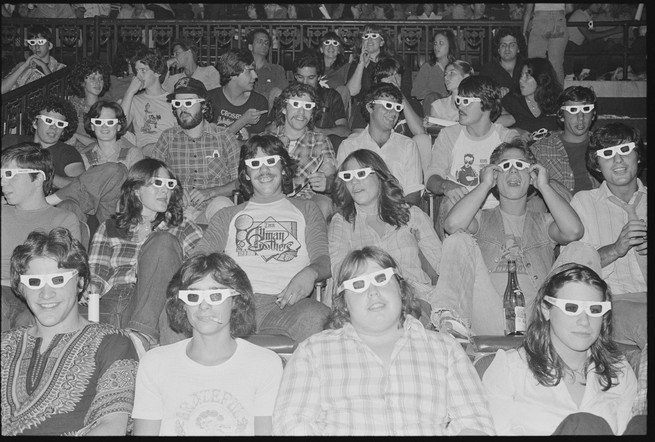 Moviegoers in a theater wearing with 3-D glasses