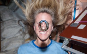 NASA astronaut Karen Nyberg smiles behind a floating bubble of water on the International Space Station