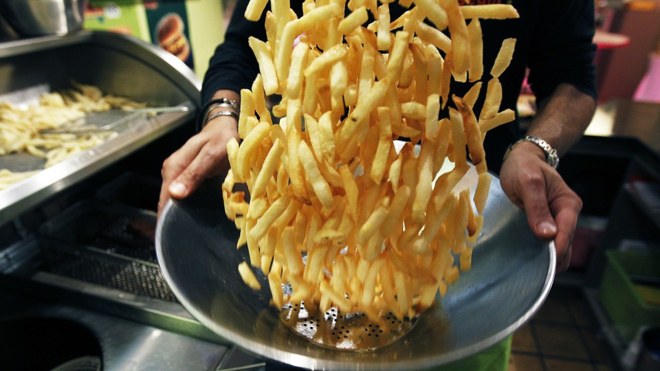 A chef flips french fries during a cooking demonstration at the Frietmuseum in Brussels.