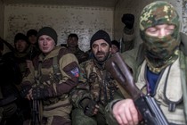 Pro-Russian rebels sit inside a truck, holding guns.