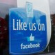 A window advertisement that says "Like us on Facebook"
