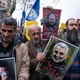 Protesters holding posters of Qassem Suleimani