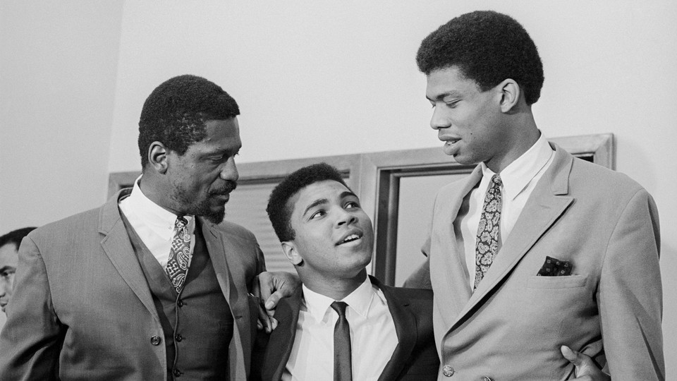 a black-and-white photo of Bill Russell, Muhammad Ali, and Kareem Abdul-Jabbar