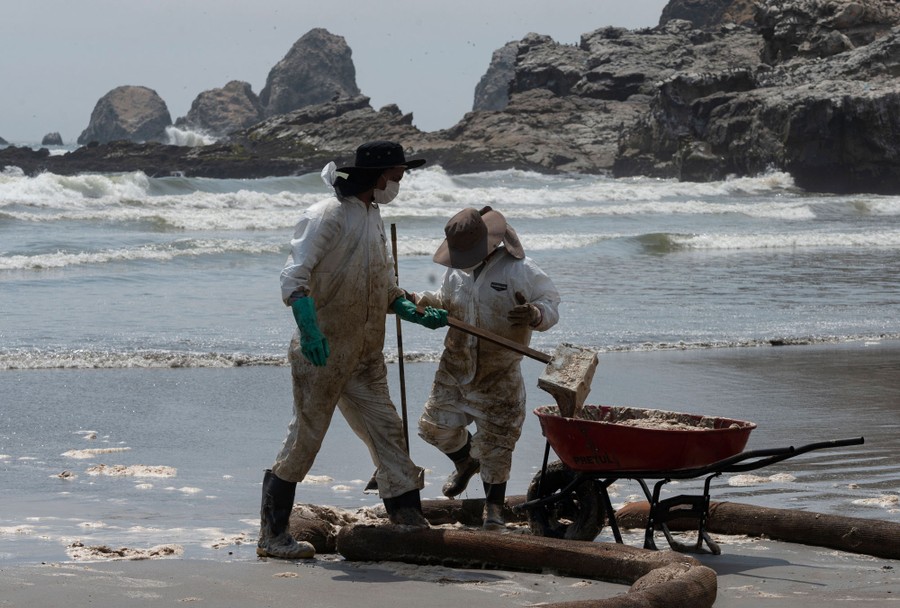 Cleaning crews work to remove oil from a beach.