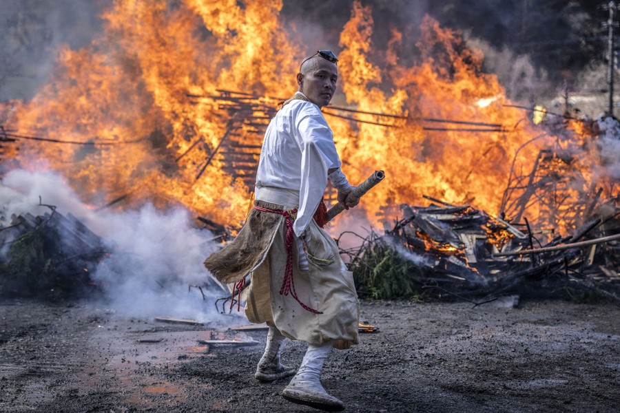 A Buddhist monk in Japan tends to a huge fire during a festival.