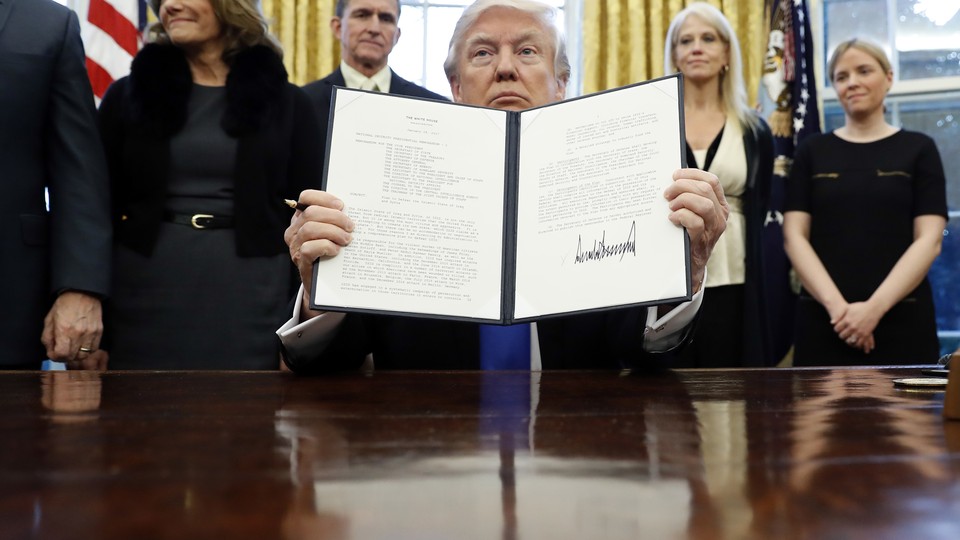 President Donald Trump holds up a signed presidential memorandum that directs his administration to "develop a comprehensive plan to defeat ISIS."