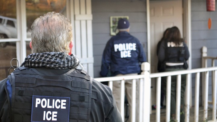 Police officers wearing ICE vests and jackets