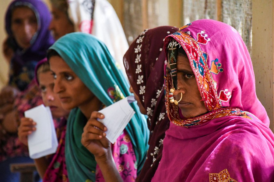 About six women sit in a waiting area.