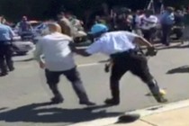 A still image of a police officer chasing a protester during a violent clash outside the Turkish ambassador's residence between in Washington, D.C., on May 16, 2017. 