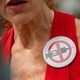 A woman wearing an anti-vax pin.