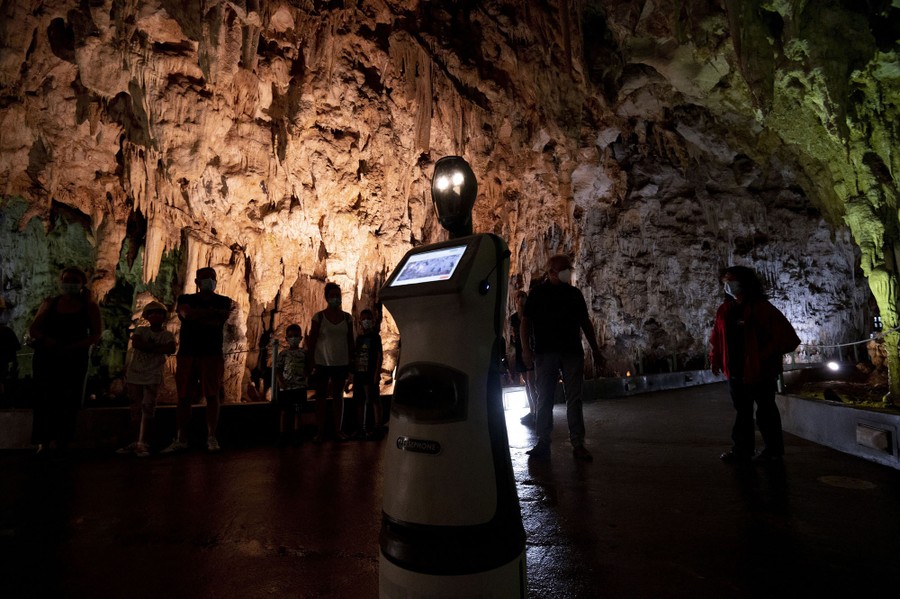 A robot moves about inside a tourist cave.