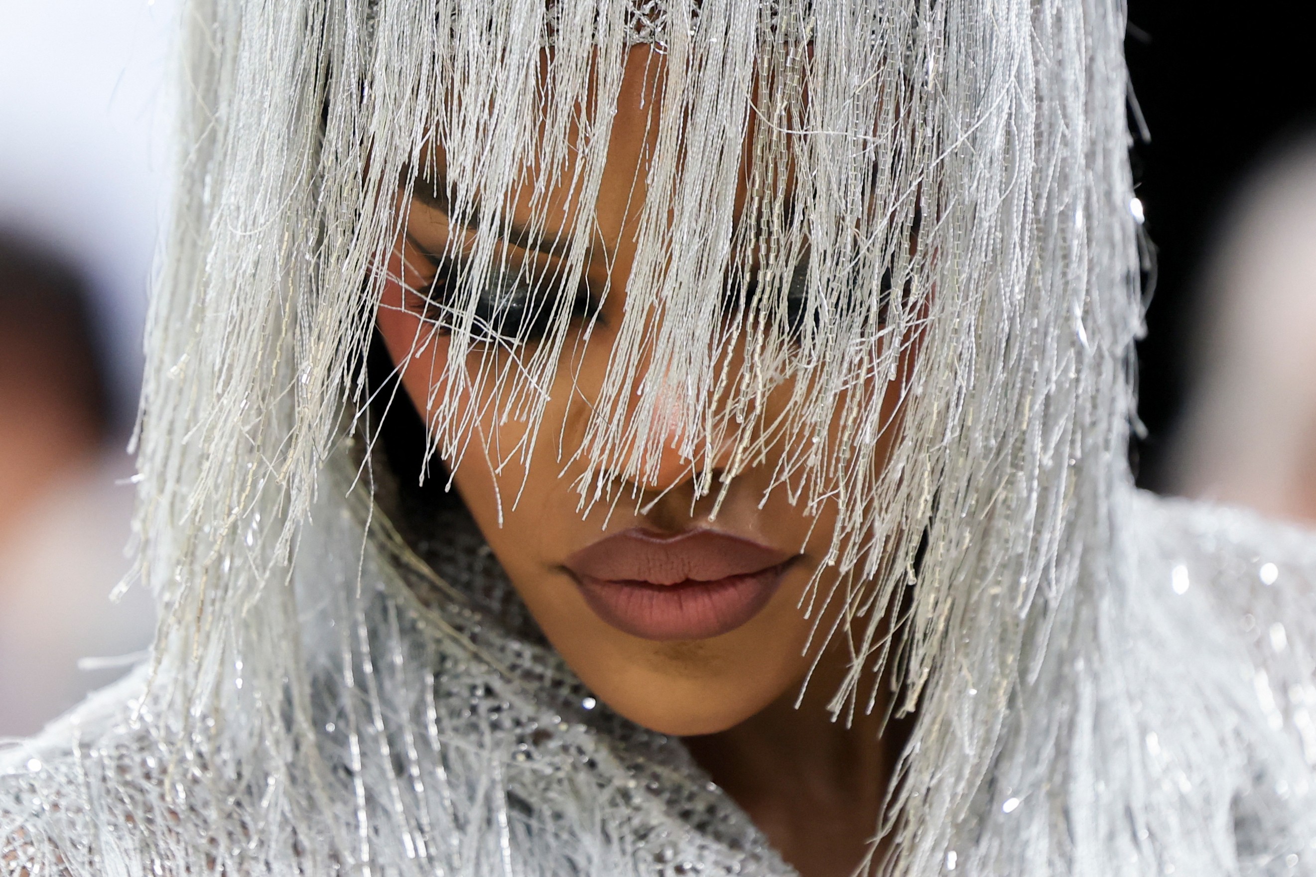 A close view of Teyana Taylor wearing a shimmering, silvery flowing garment and hood.