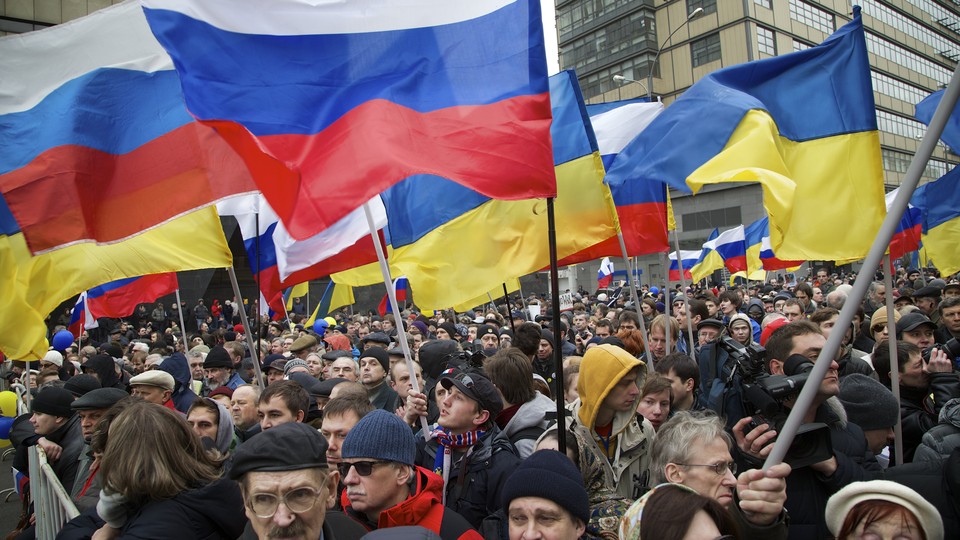 Demonstrators hold Russian and Ukrainian flags.