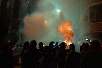 An image of protesters in front of the Georgian Parliament throwing fireworks