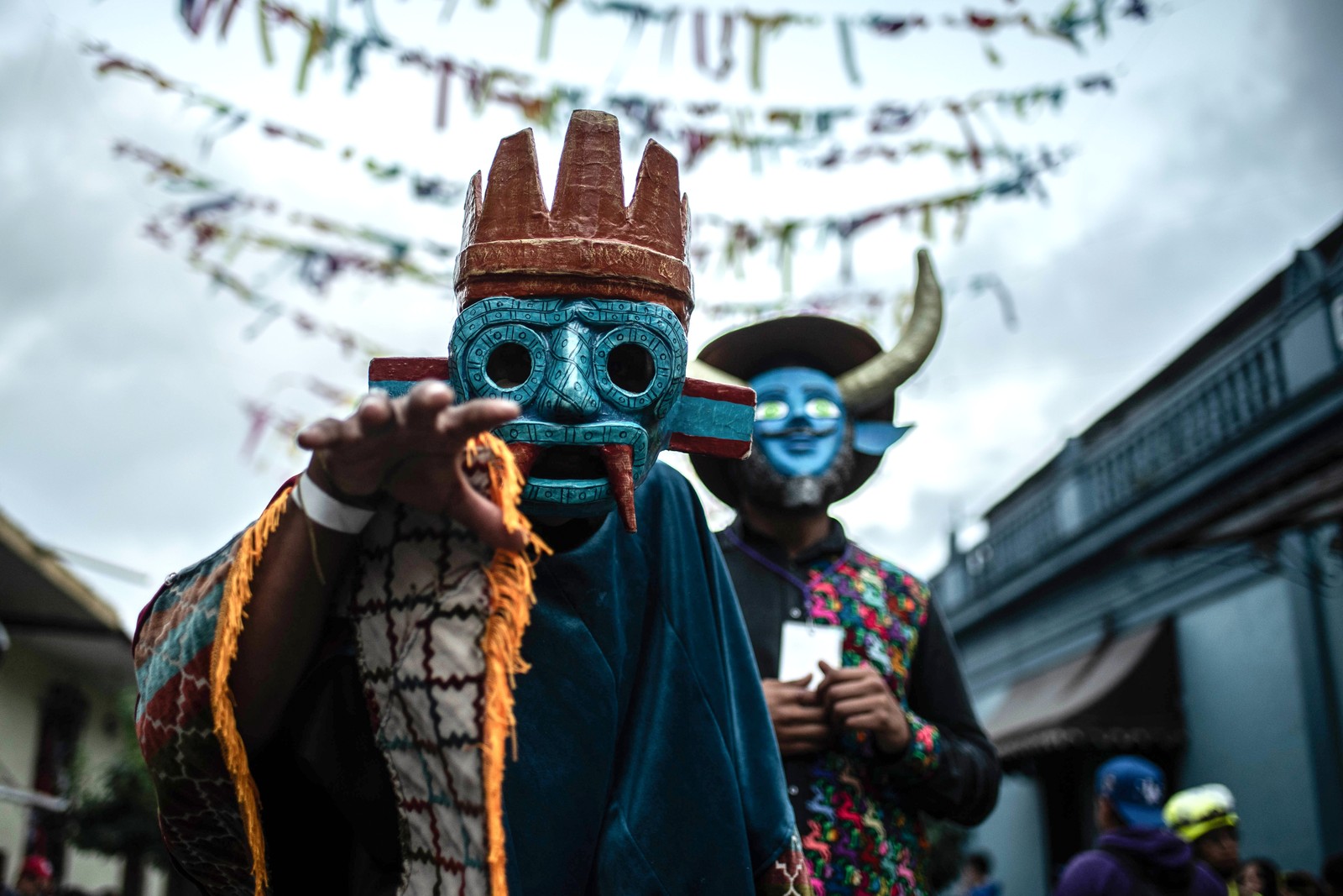 Dancers wearing frightening masks pose during a festival.