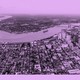 A drone photo of downtown New Orleans and the Mississippi River, with the French Quarter in the foreground and the West Bank in the distance