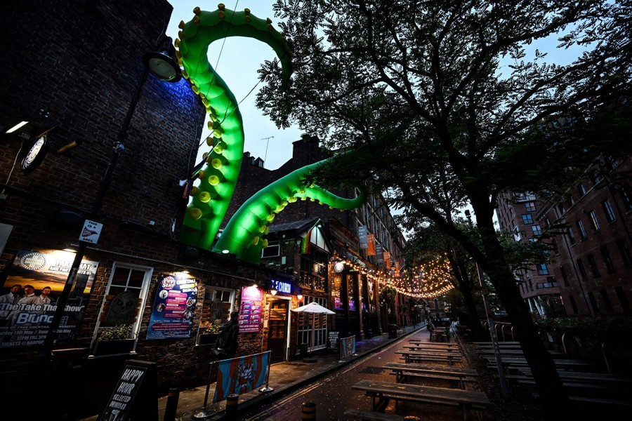 Several large inflatable tentacles appear to poke out of the roof of a night club.