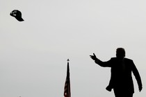 A silhouette of Donald Trump throwing a hat into a crowd