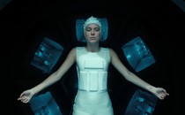 Millie Bobby Brown as Eleven lying with eyes closed, wearing a white body suit