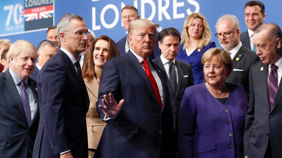 NATO Secretary General Jens Stoltenberg, U.S. President Donald Trump, Germany's Chancellor Angela Merkel, Turkey's President Recep Tayyip Erdogan and other NATO leaders leave the stage after family photo during the annual NATO heads of government summit near London.