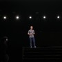 Mark Zuckerberg on a stage being photographed and lit by spotlights
