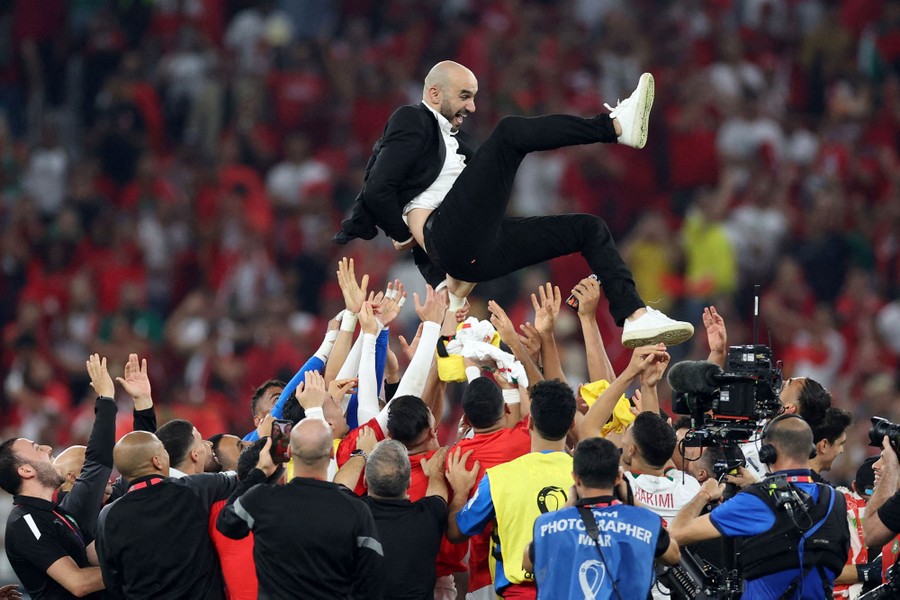 A man is tossed into the air by a celebrating soccer team.